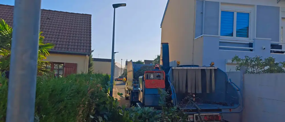 Le gros broyeur garé dans la rue, au bout de l'allée